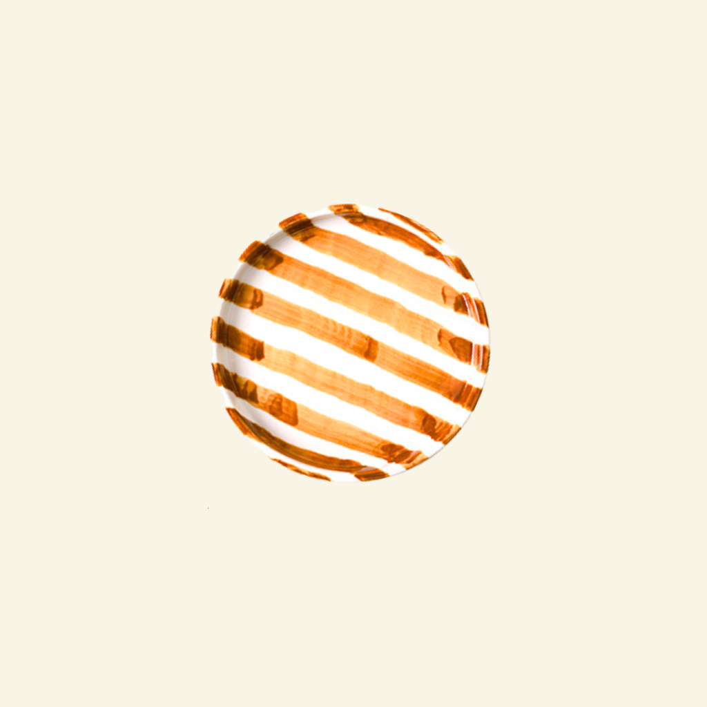 Orange and white striped artisan handmade ceramic plate on a beige background