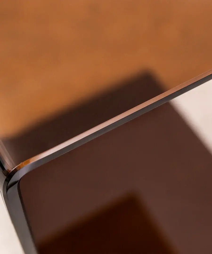 Close-up of curved orange acrylic edge – showcasing craftsmanship and material detail of designer side table.