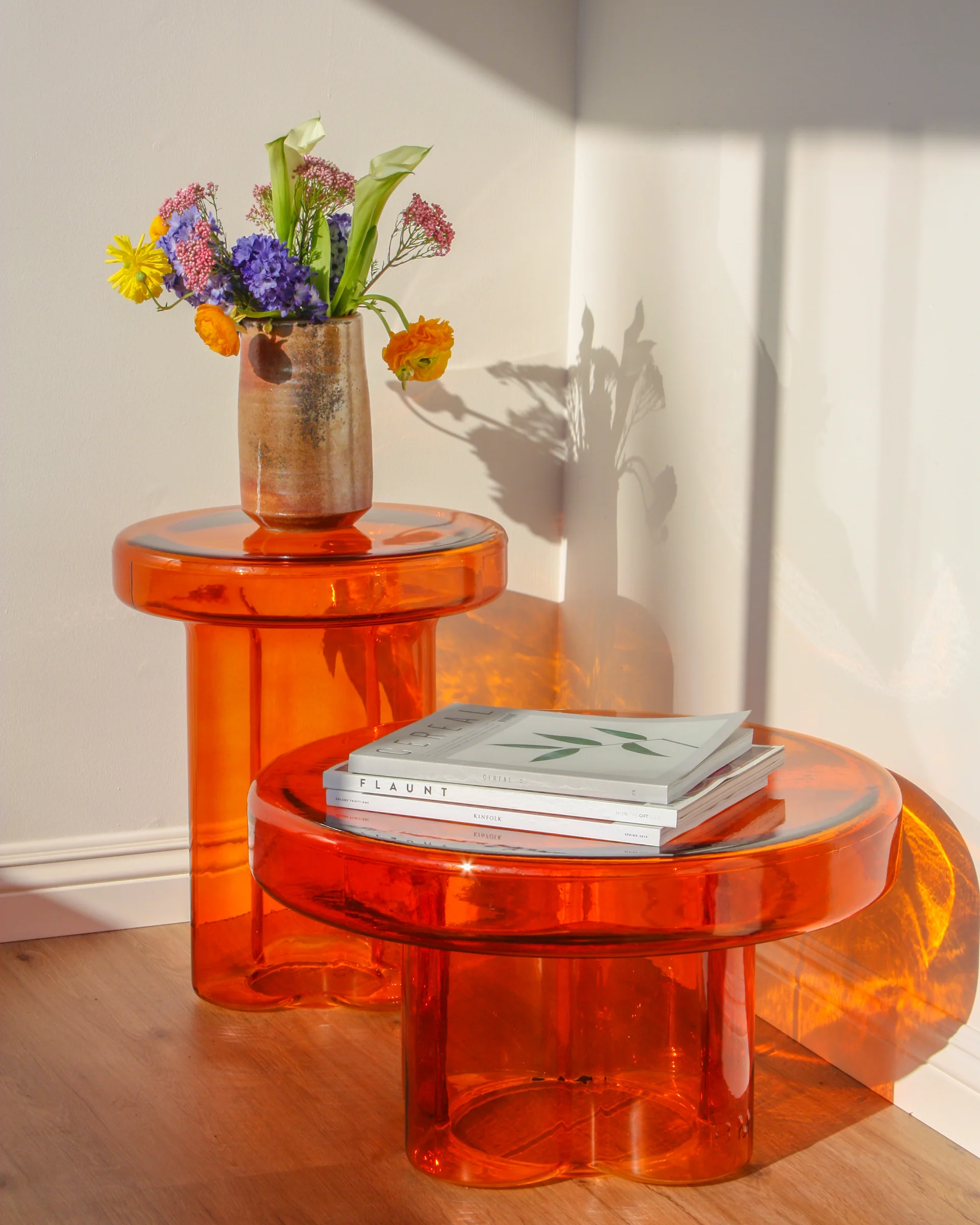 Elegant modern side table crafted from handblown amber glass with a unique art-inspired design, ideal for high-end living room styling