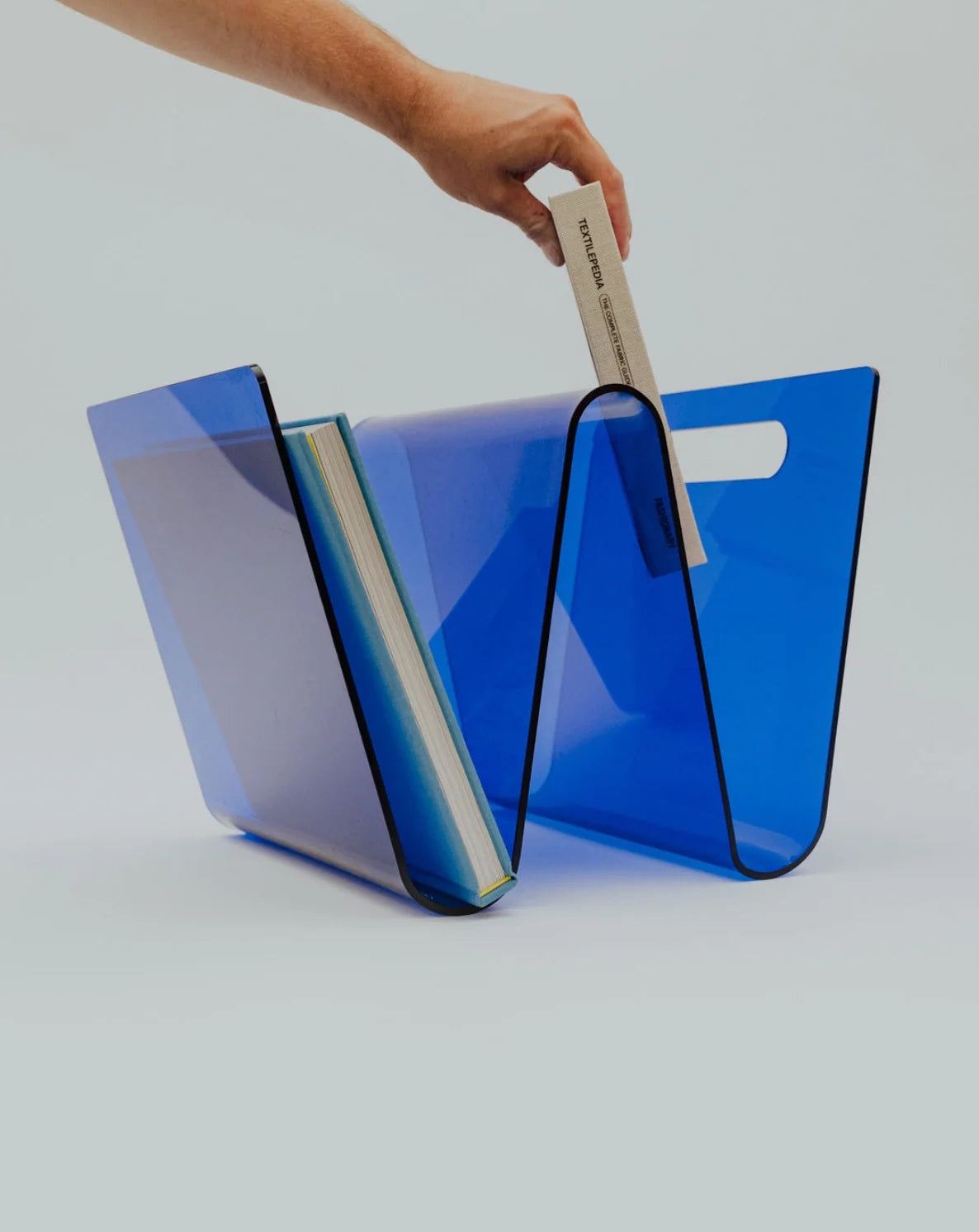 Blue acrylic designer magazine rack on a white background