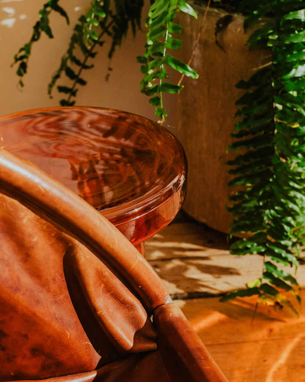 Amber glass side table with petal-shaped base and textured glass top, perfect as a modern coffee or accent table