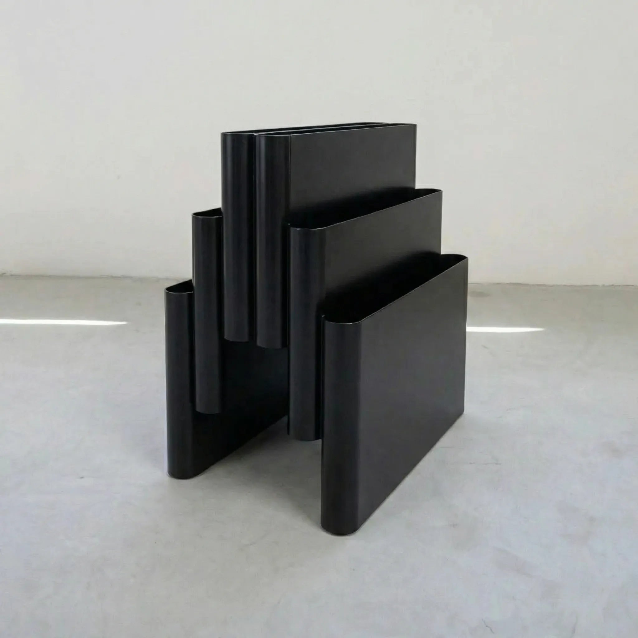 Black kartell magazine rack replica on a white surface