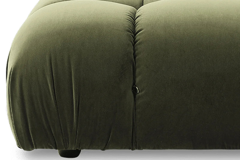 Close-up of a green camaleonda sofa with a button detail on a light gray background