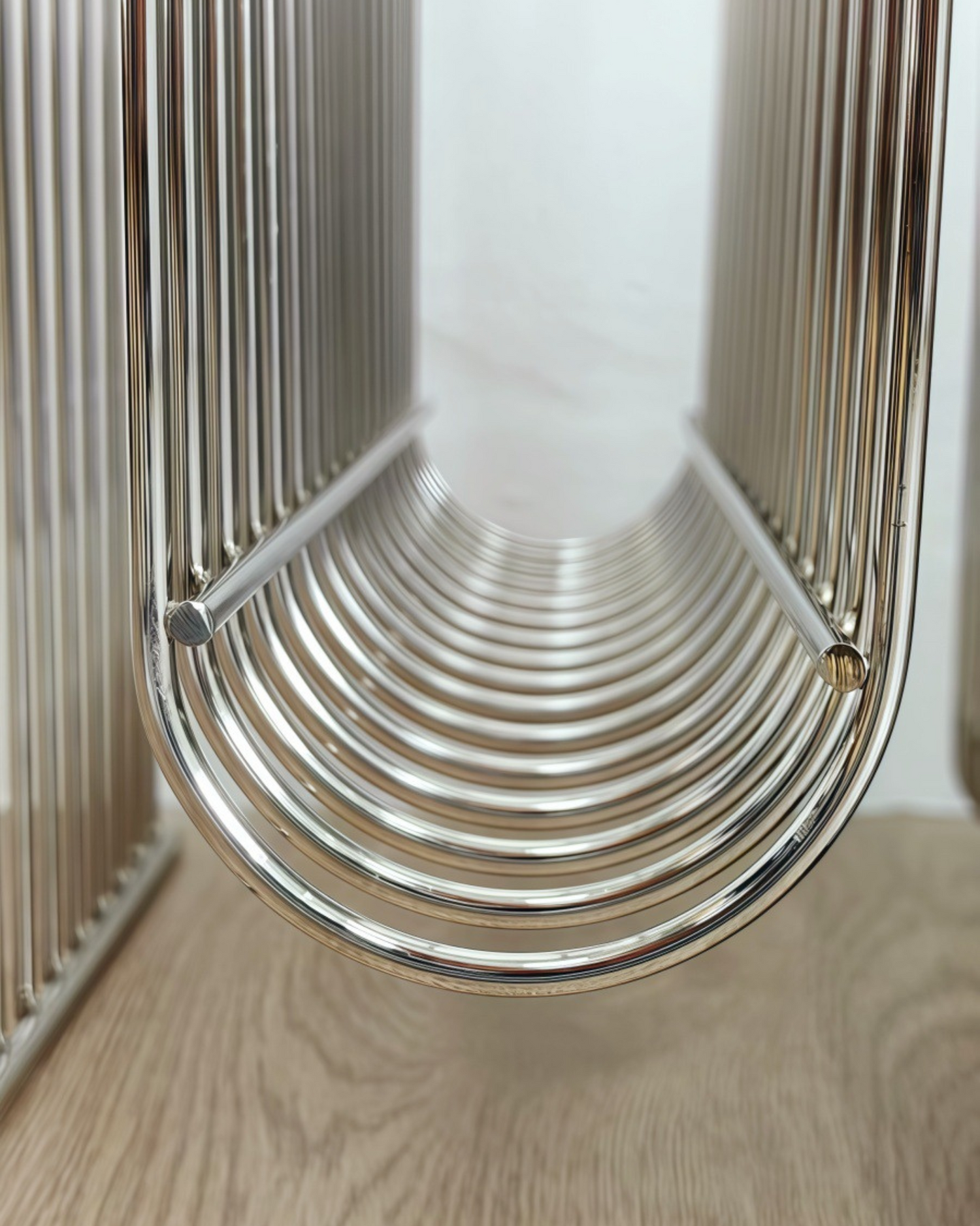 Metal Magazine Rack object on a wooden surface with a neutral background