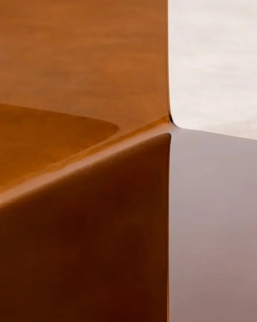 Close-up of curved orange acrylic edge – showcasing craftsmanship and material detail of designer side table.