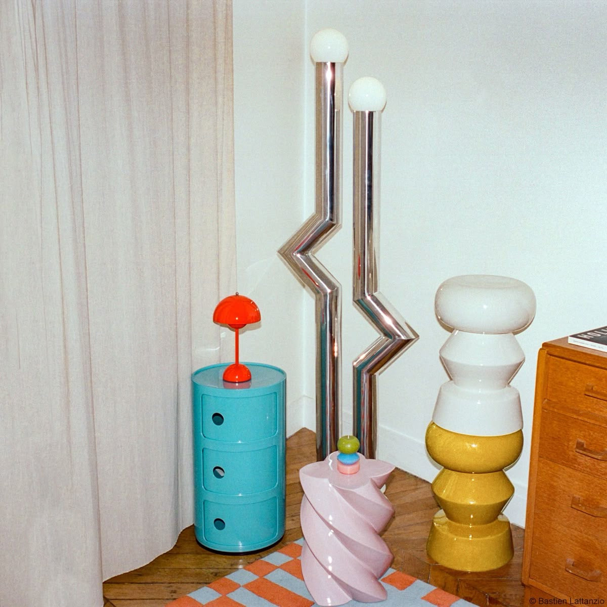 Decorative componibili dupe table with colorful lamps and a blue cylindrical object.