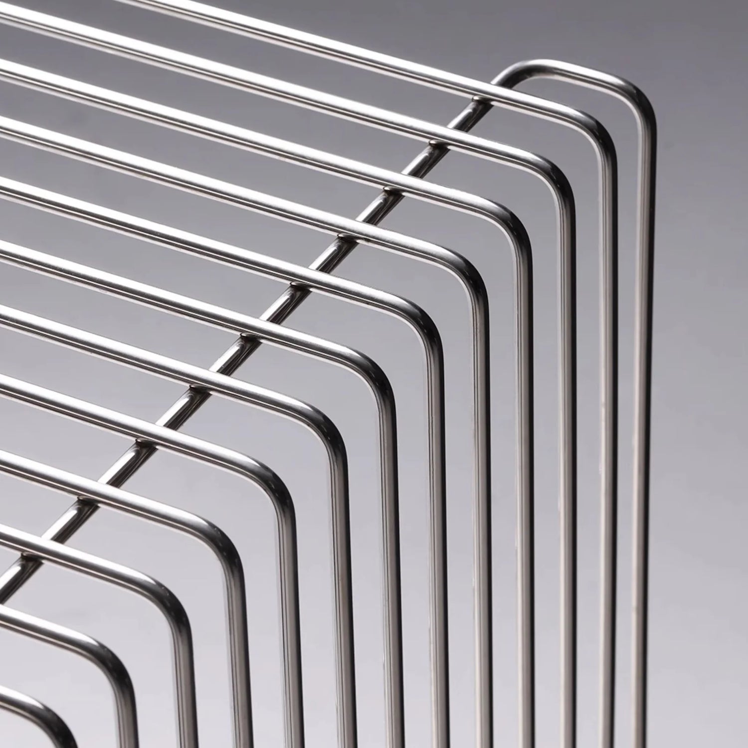 Detail view of the chrome wireframe construction of the modern wire side table, highlighting its polished finish and modular build.