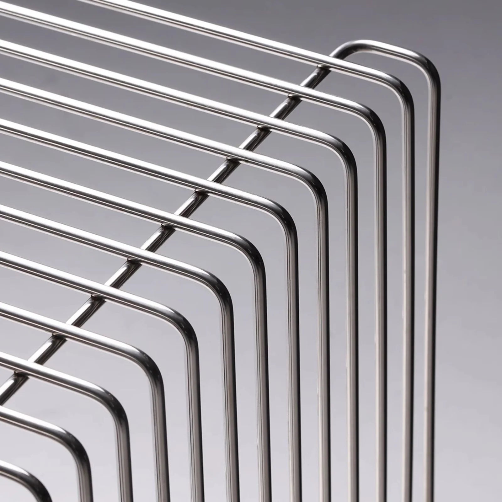 Detail view of the chrome wireframe construction of the modern wire side table, highlighting its polished finish and modular build.
