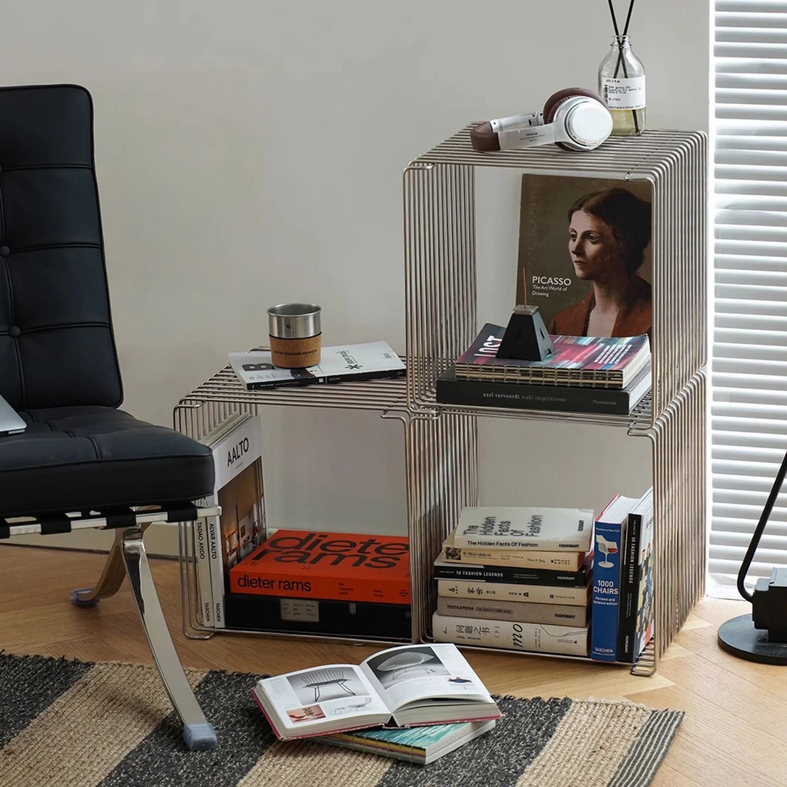 Chrome wire cube used as a modern side table in a contemporary living room with neutral tones and minimalist decor.