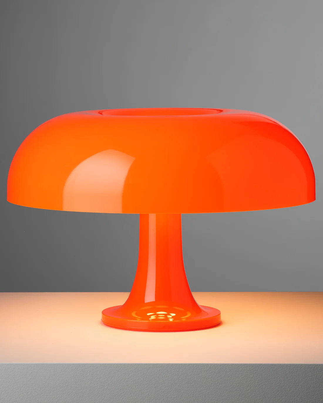 Orange Nesso Replica mushroom shaped table lamp on a gray background