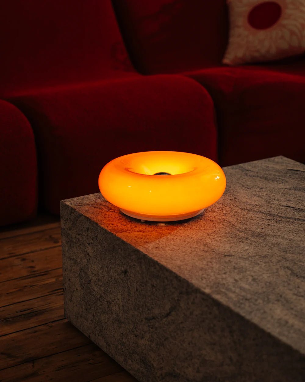 Decorative orange round LED lamp with donut silhouette, designed for bold, modern interiors.