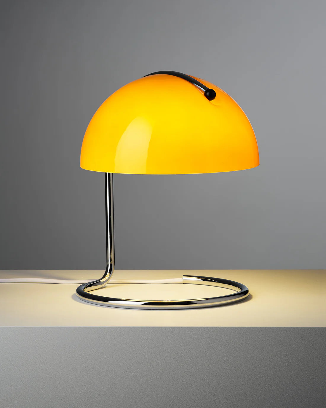 Yellow curved aromatherapy table lamp with a gray background