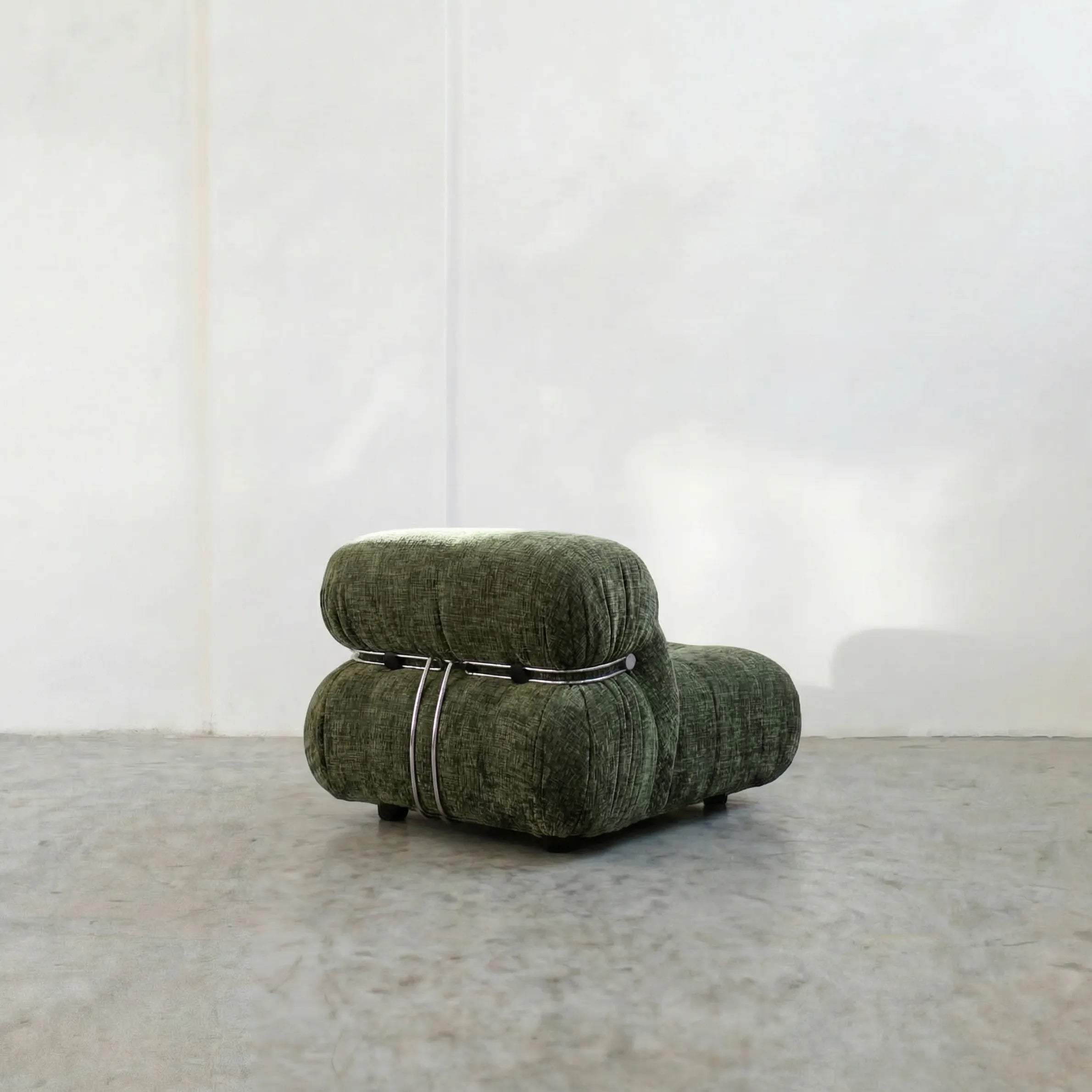 soriana chair dupe in green chenille angled view on gray floor with white wall background