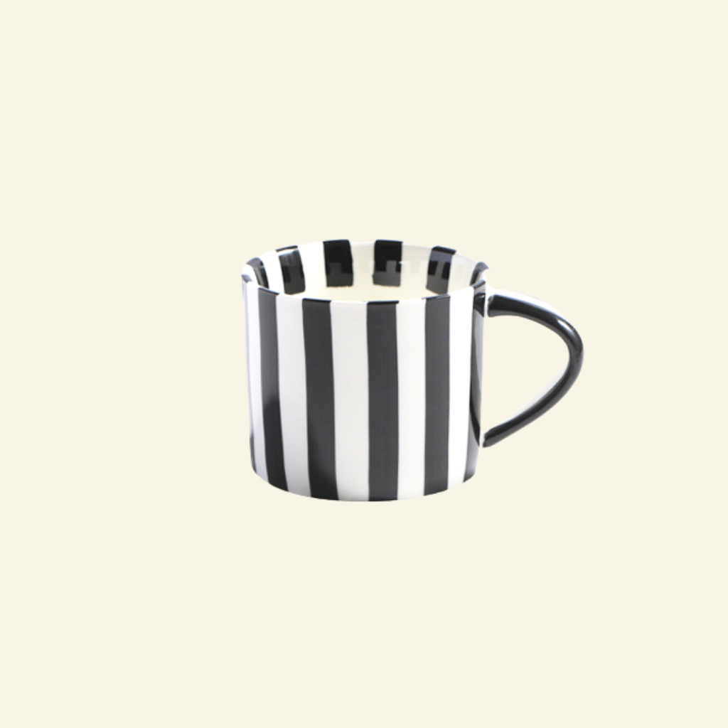 Black and white striped Artisan Ceramic Mug on a beige background