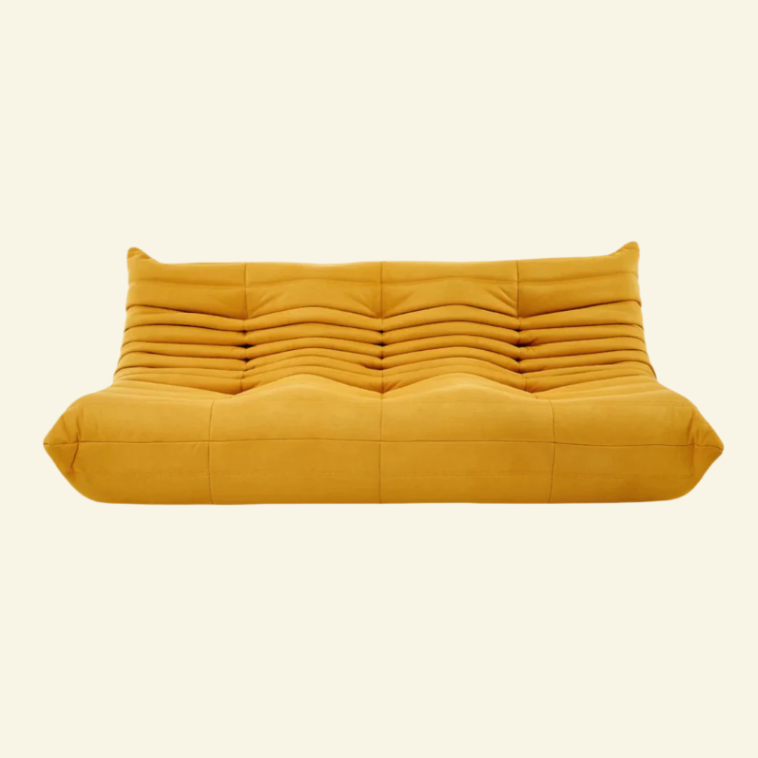 Togo-style 3-seater velvet sofa with low-profile design, plush channel tufting, and sculptural curves — inspired by Michel Ducaroy, ideal for modern interiors.