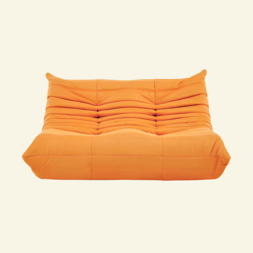 Togo-style orange 2-seater velvet sofa with low-profile design, plush channel tufting, and sculptural curves — inspired by Michel Ducaroy, ideal for modern interiors.