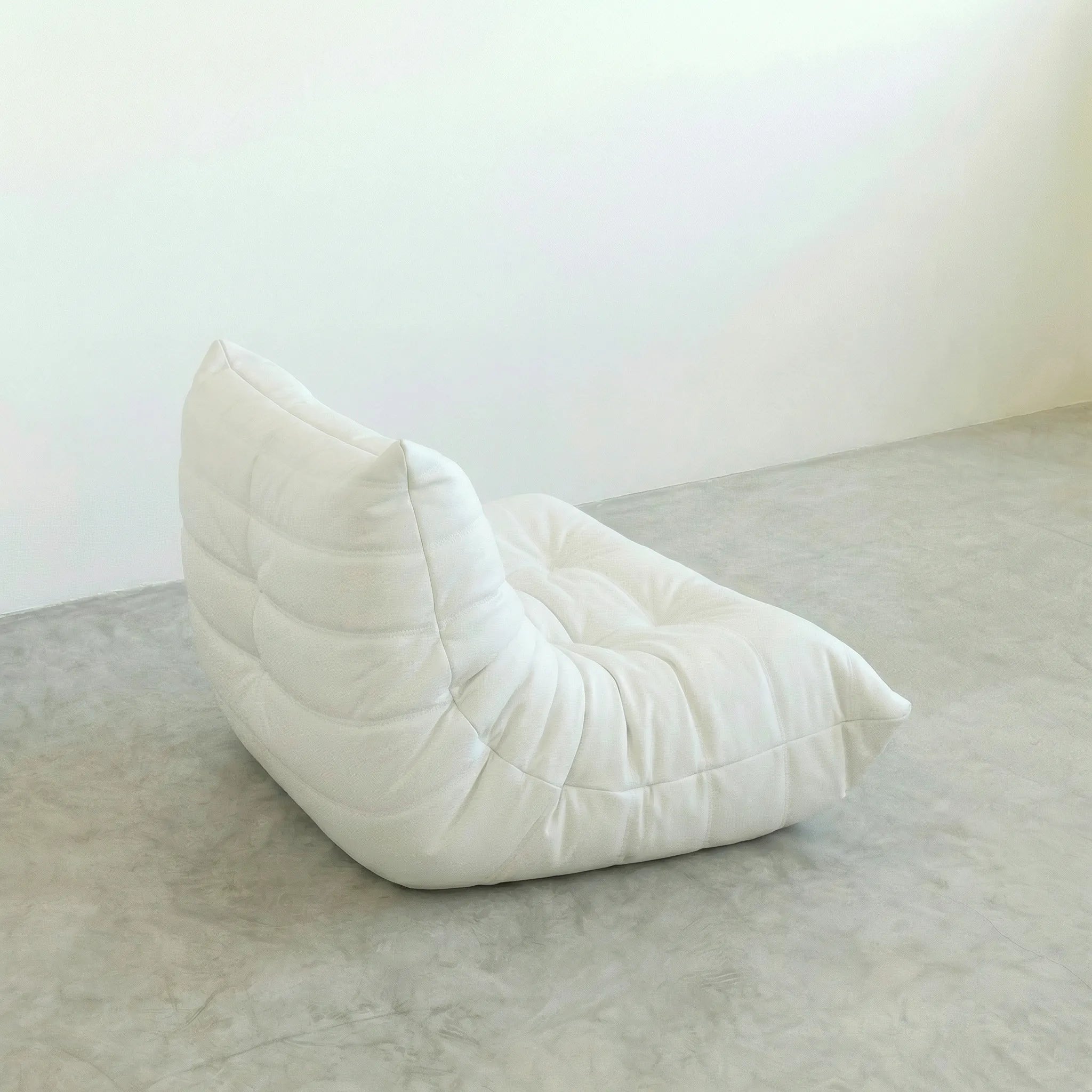 White togo leather sofa dupe on a gray floor with a white wall background