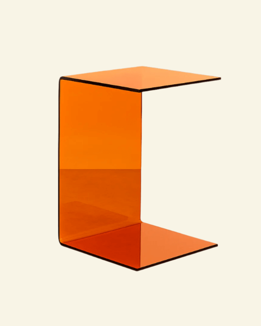 Translucent orange acrylic C-shaped side table with curved edges – bold modern side table for stylish interiors.