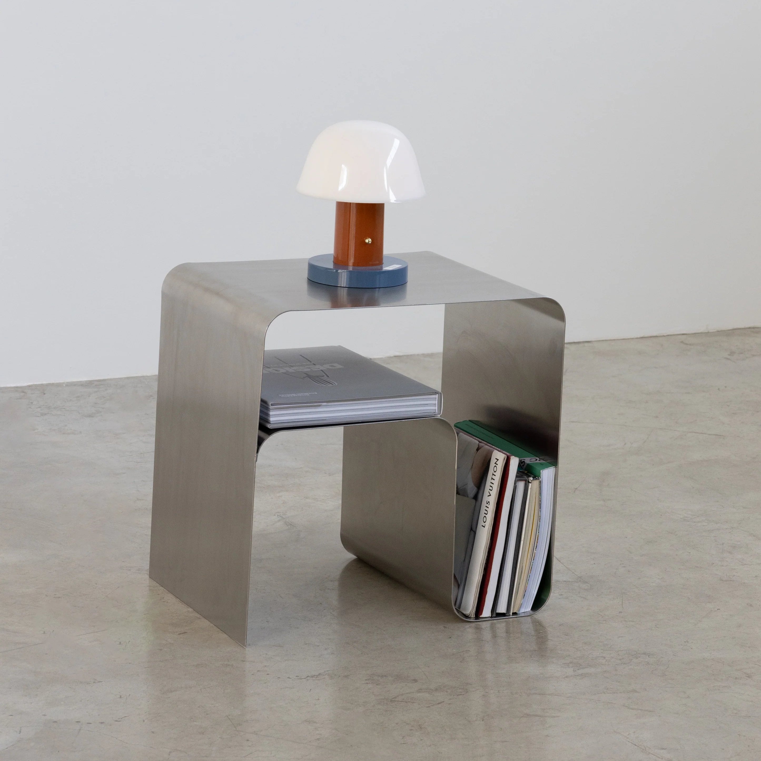 Modern bauhaus metal side table with a lamp and books on a neutral background by vibehaus