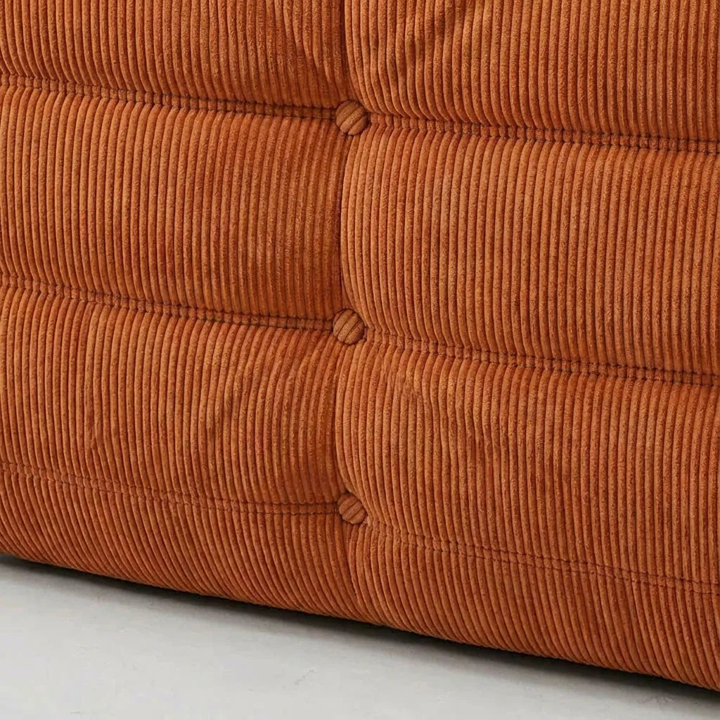 Close-up of an Bruma Sofa Corner in orange corduroy on a light gray background