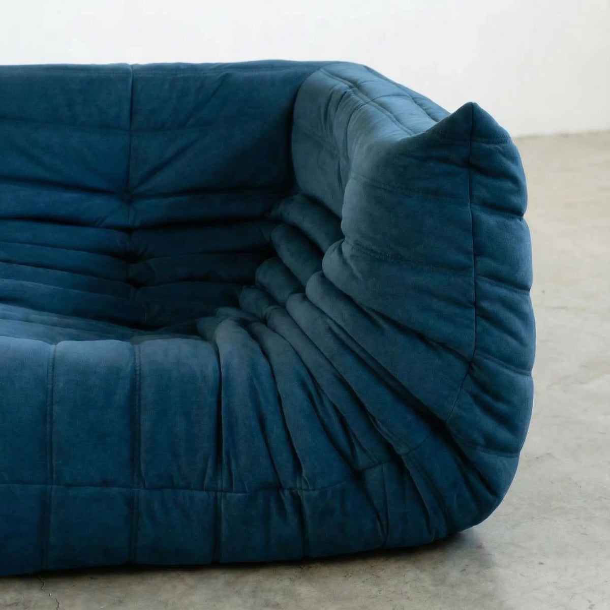 close up of the Bruma Sofa Corner in dark blue velvet suede photographed from the side angle.