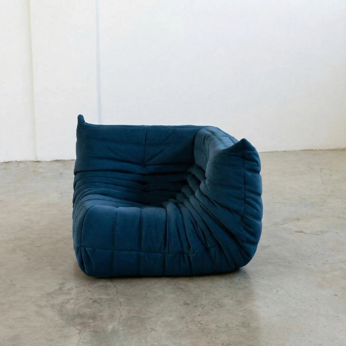 Bruma Sofa Corner in dark blue velvet suede photographed from the front angle.