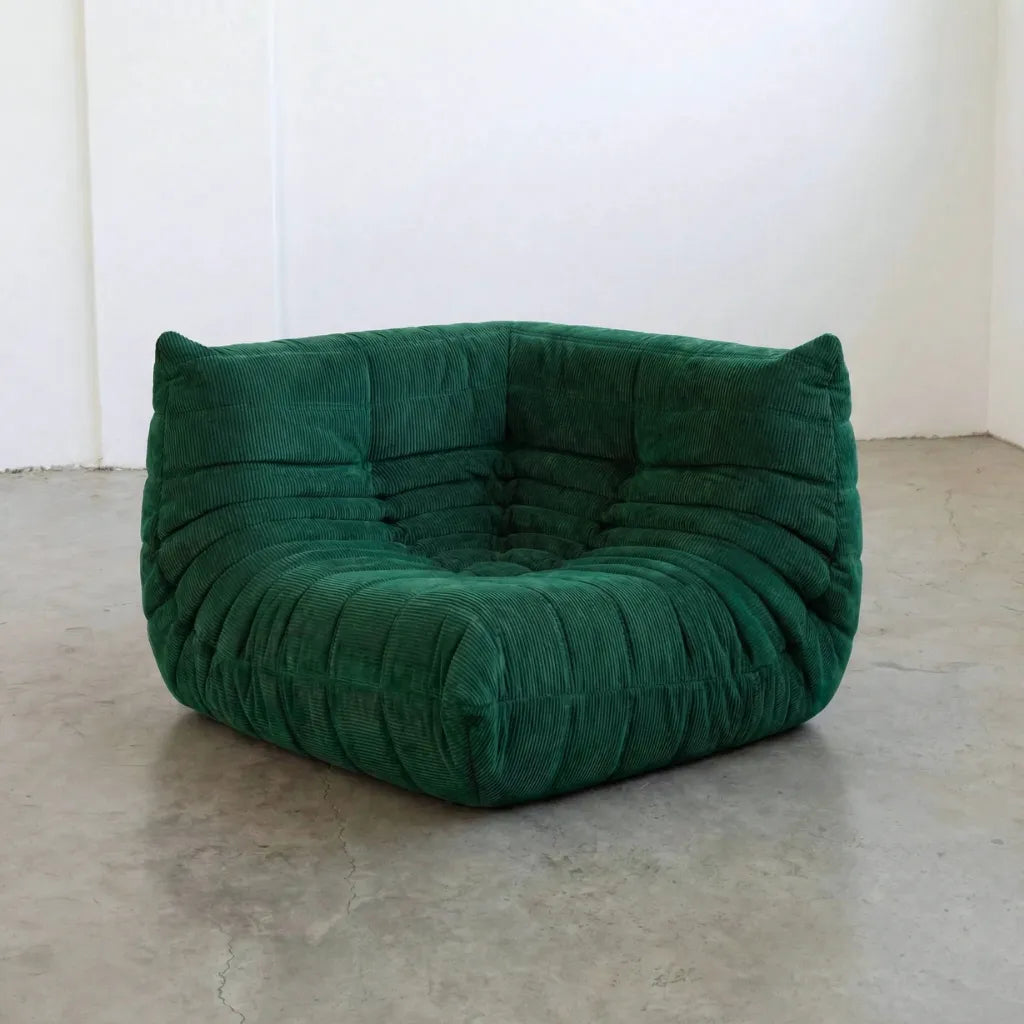 Bruma Sofa Corner in dark green corduroy photographed from the front angle.