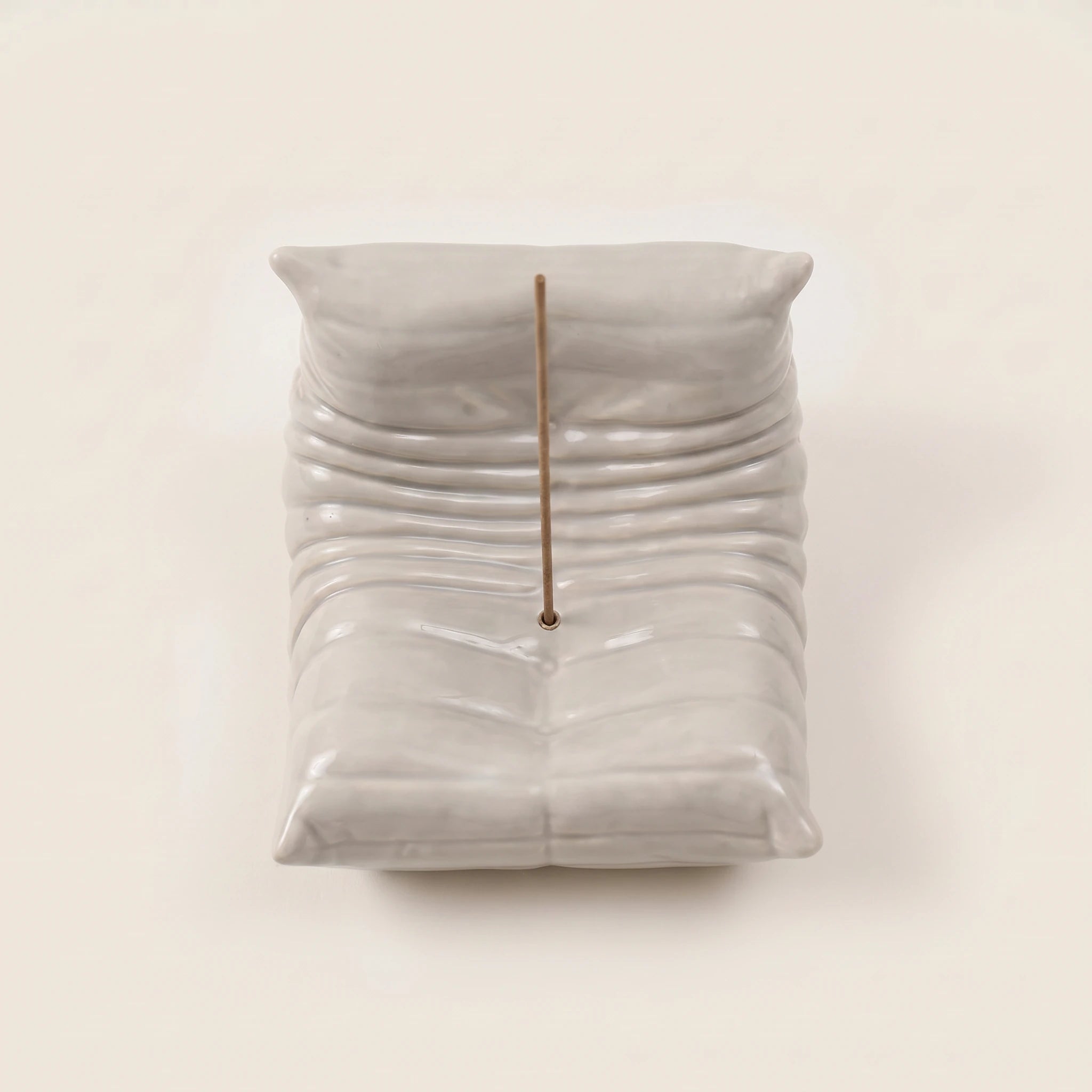 Top view of the grey Bruma incense holder highlighting its pleated seat shape and incense holder placement.