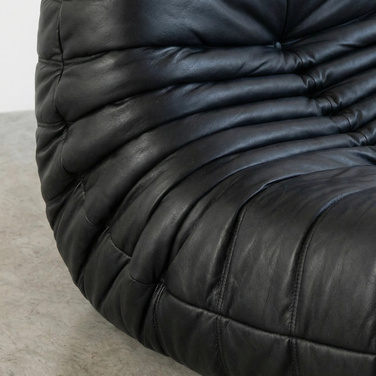 Close-up of a black leather Bruma sofa with a textured surface.