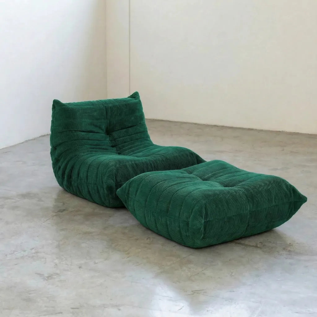 Bruma chair and ottoman in dark green corduroy by Vibehaus on a concrete floor