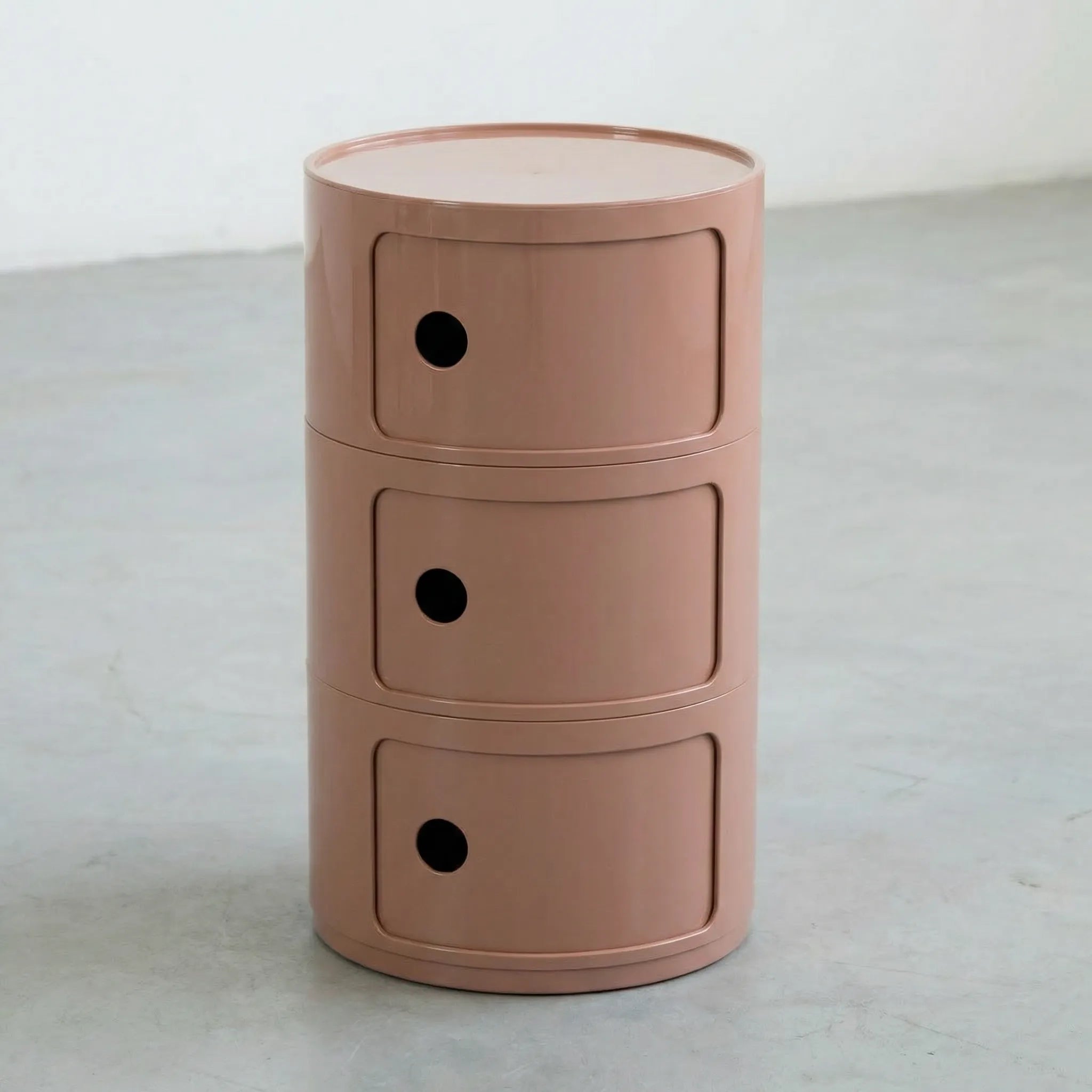 Kartell Componibili dupe round modular storage unit in glossy clay brown plastic with three tiers on concrete floor in white studio setting