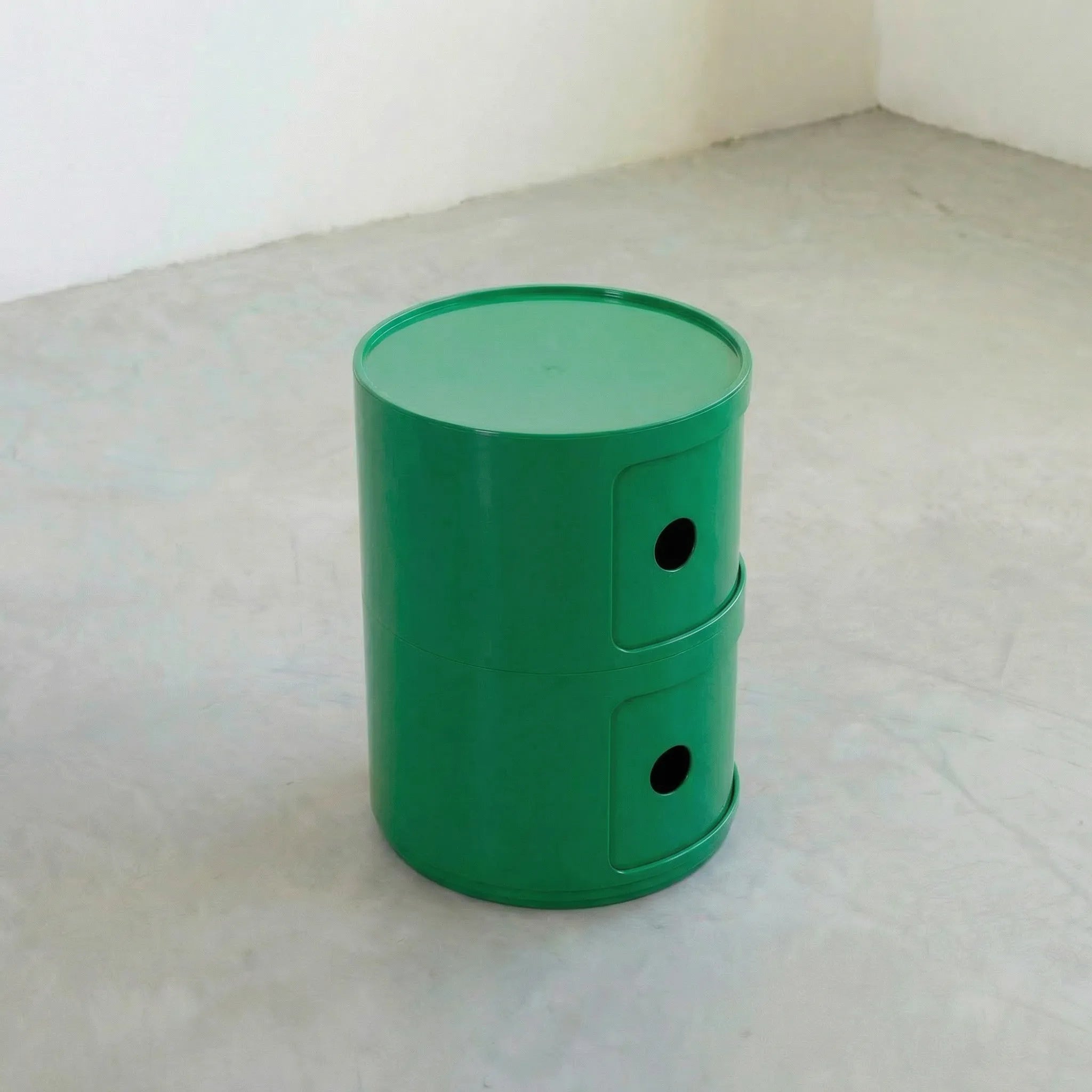 Green kartell componibili dupe storage unit with two drawers on a light gray surface.