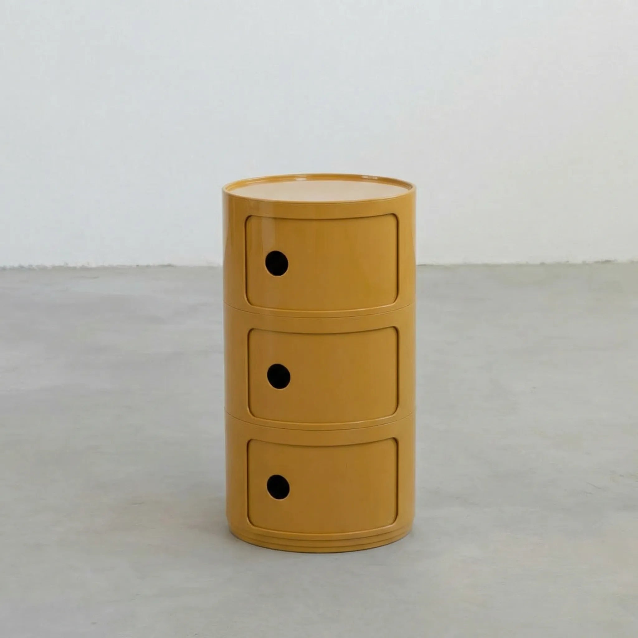 Mustard Yellow glossy round modular storage unit, Kartell Componibili dupe with three tiers in minimalist concrete studio