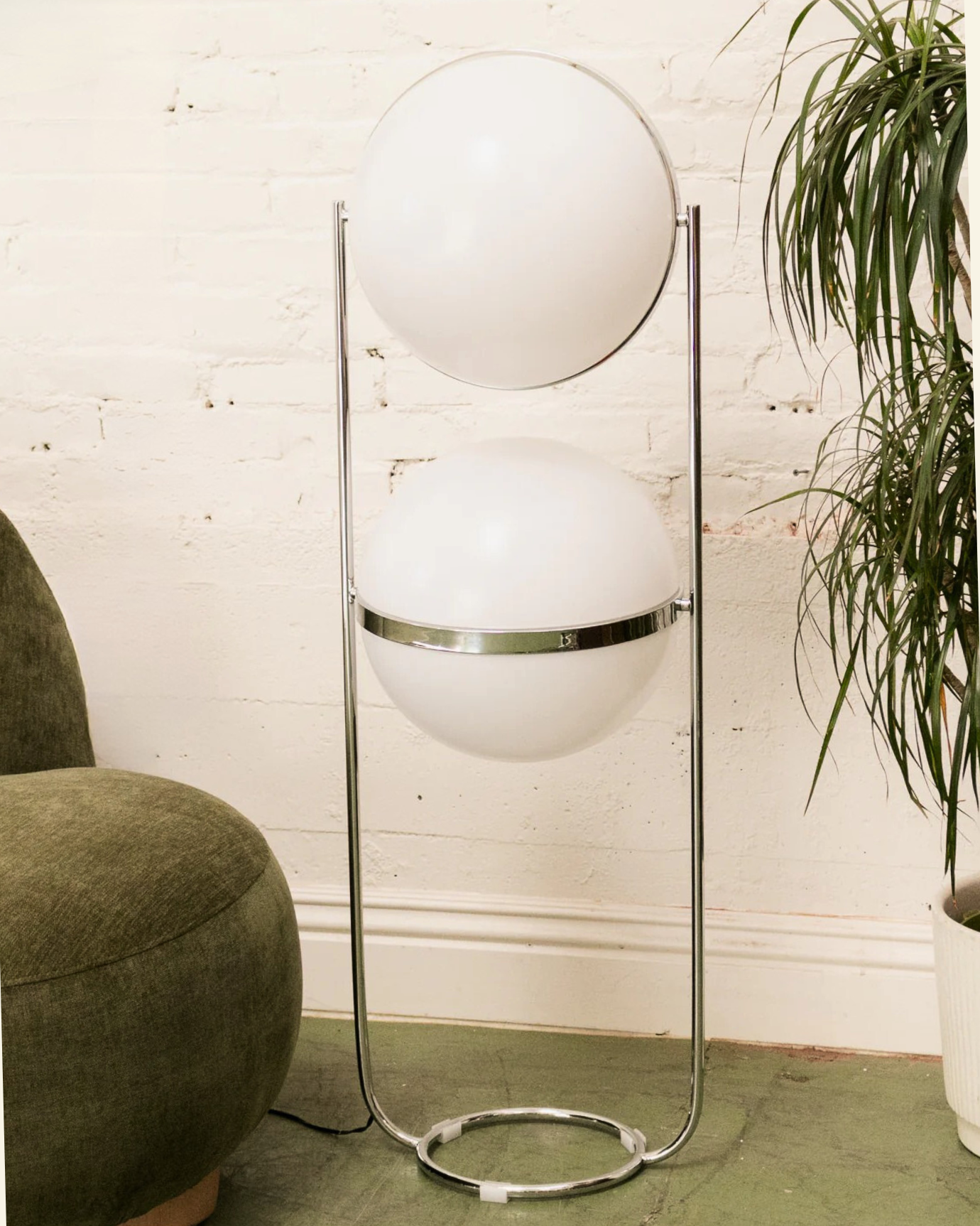 Modern floor globe double lamp with spherical white shades in a room setting.