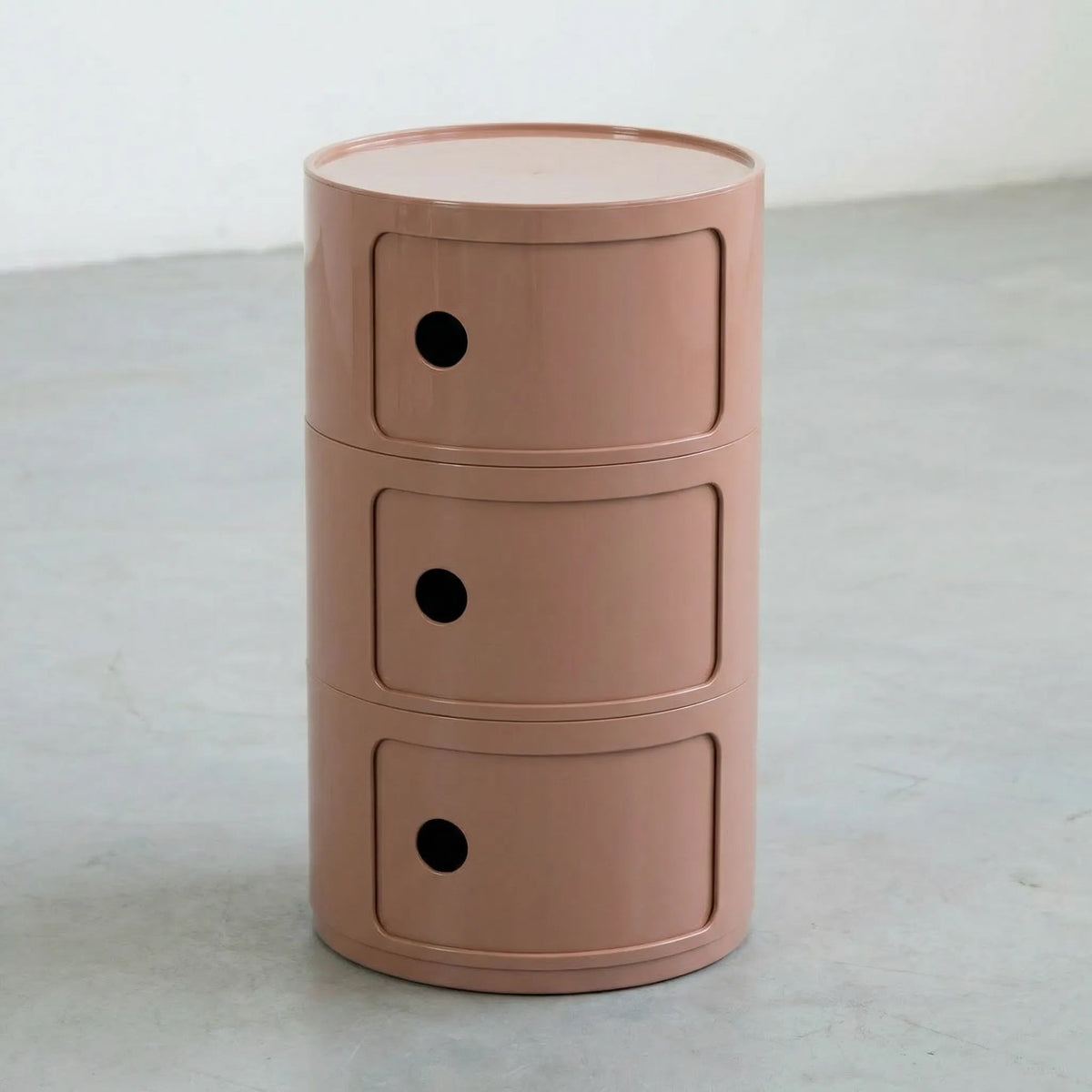 Rond modulair opbergmeubel in bruin, op een betonnen vloer.