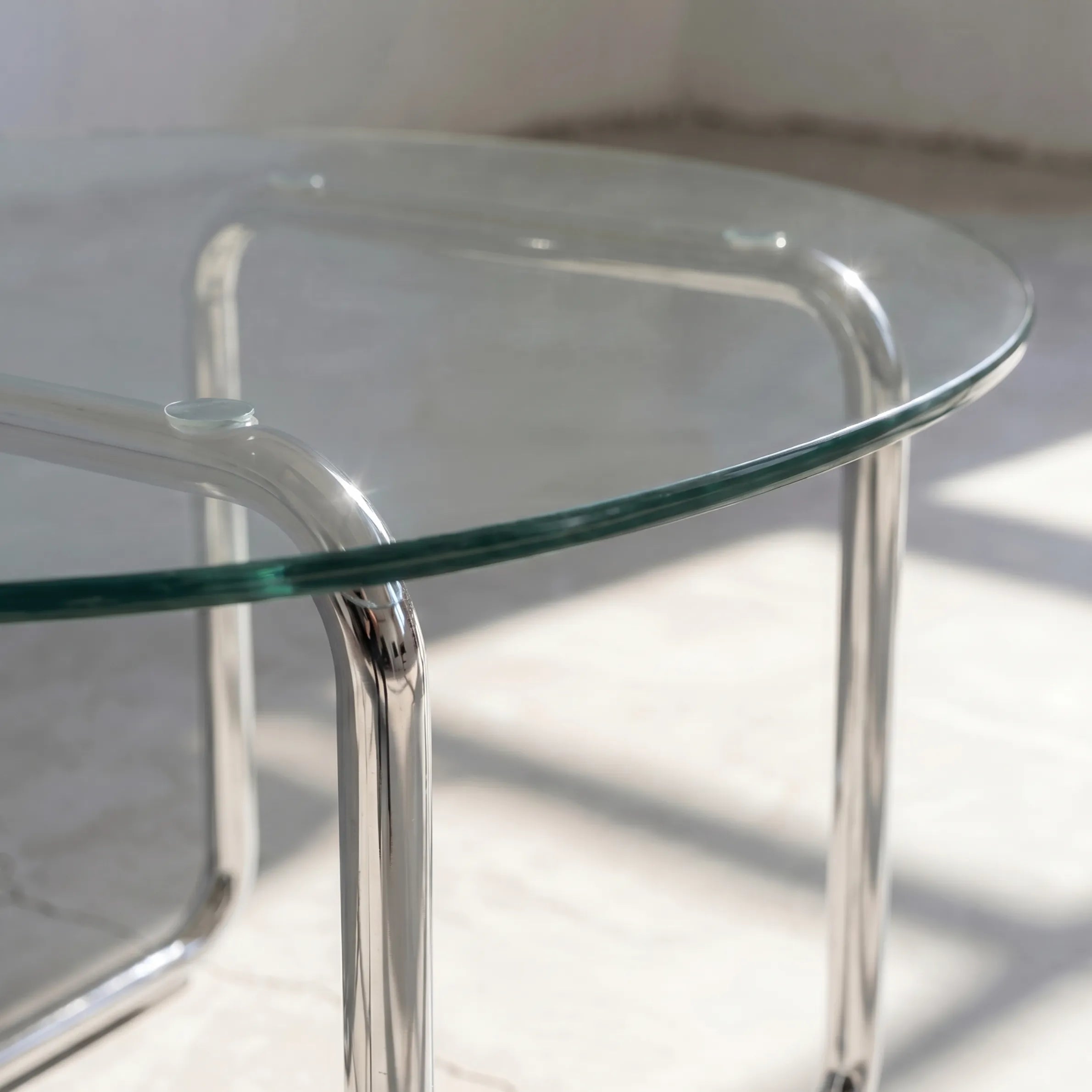 Orbit Round Glass Coffee Table, a round glass coffee table with a sculptural base for contemporary living rooms, angled view