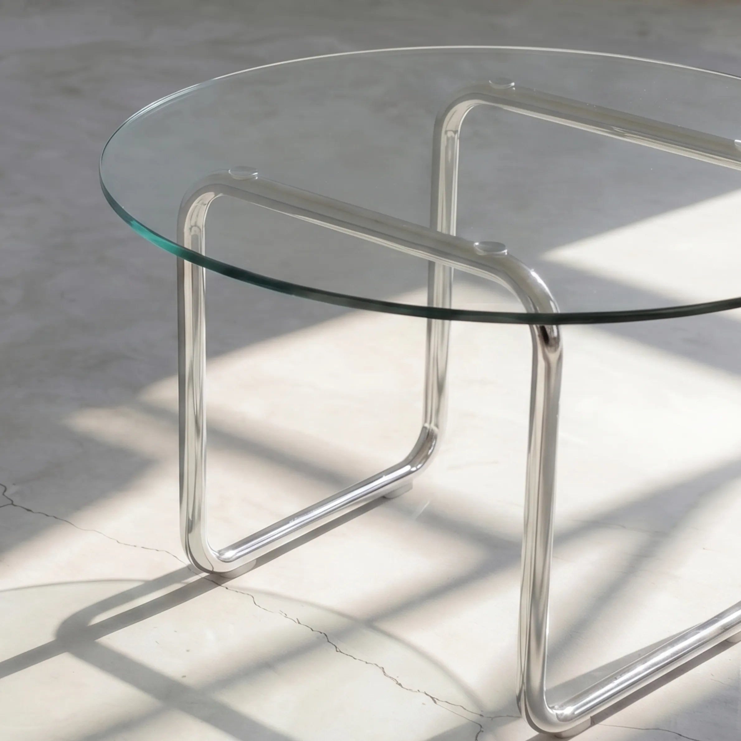 Orbit Round Glass Coffee Table, a round glass coffee table with a sculptural base for contemporary living rooms, close-up detail