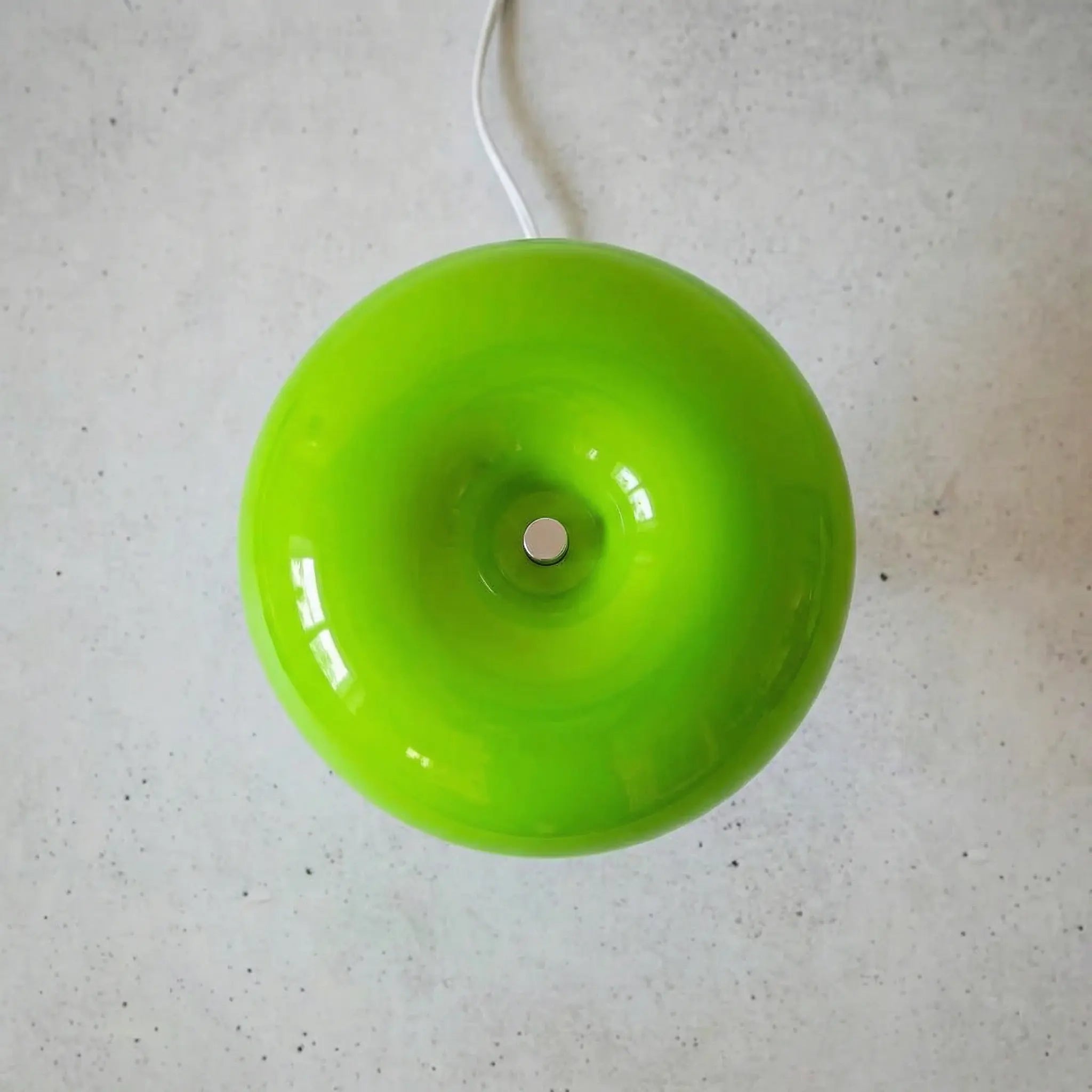 The Top of the Space age table lamp in green showing rounded glass sphere on a concrete floor.