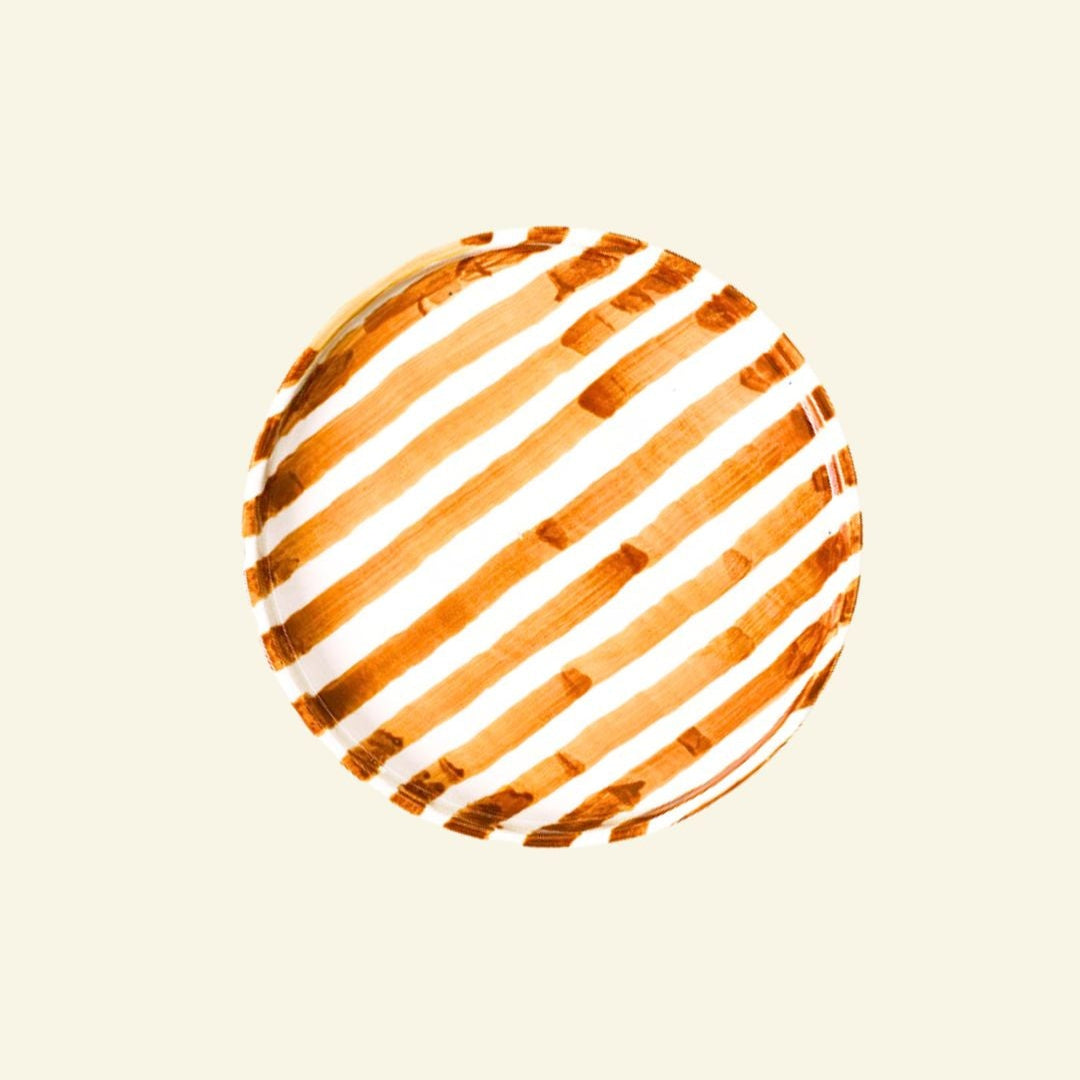 Orange-White striped artisan handmade ceramic dinner plate on a beige background