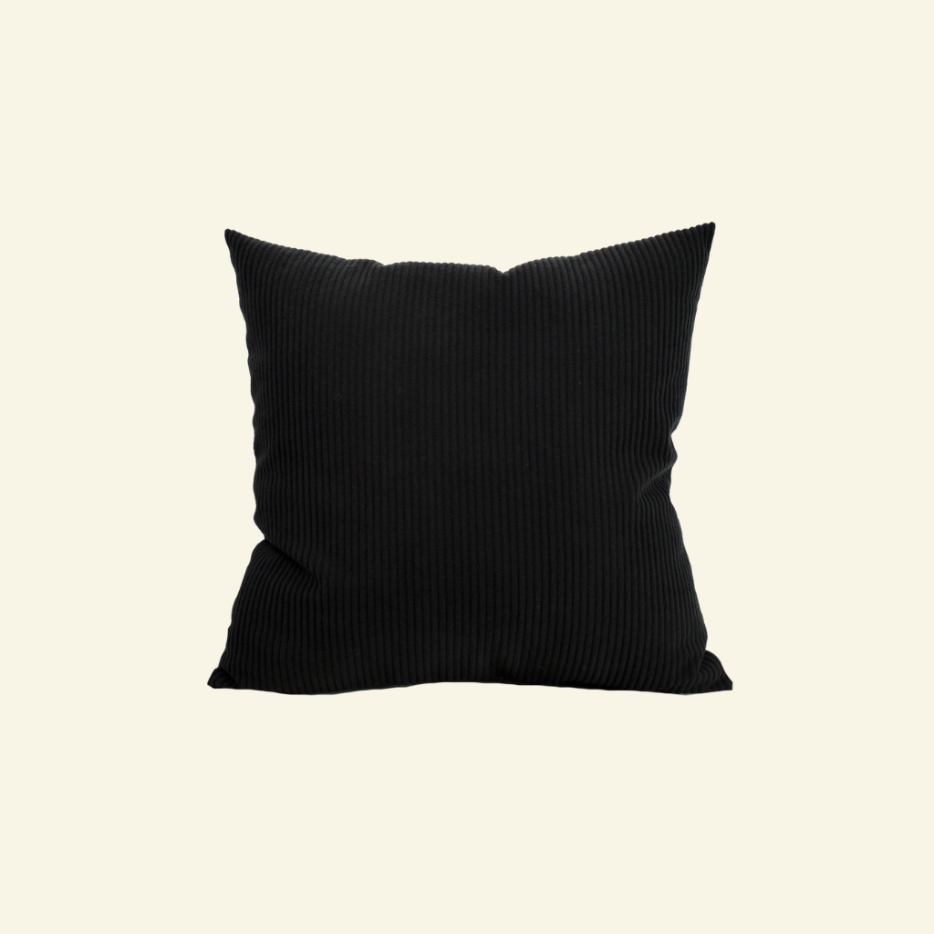 Black corduroy pillow on a beige background