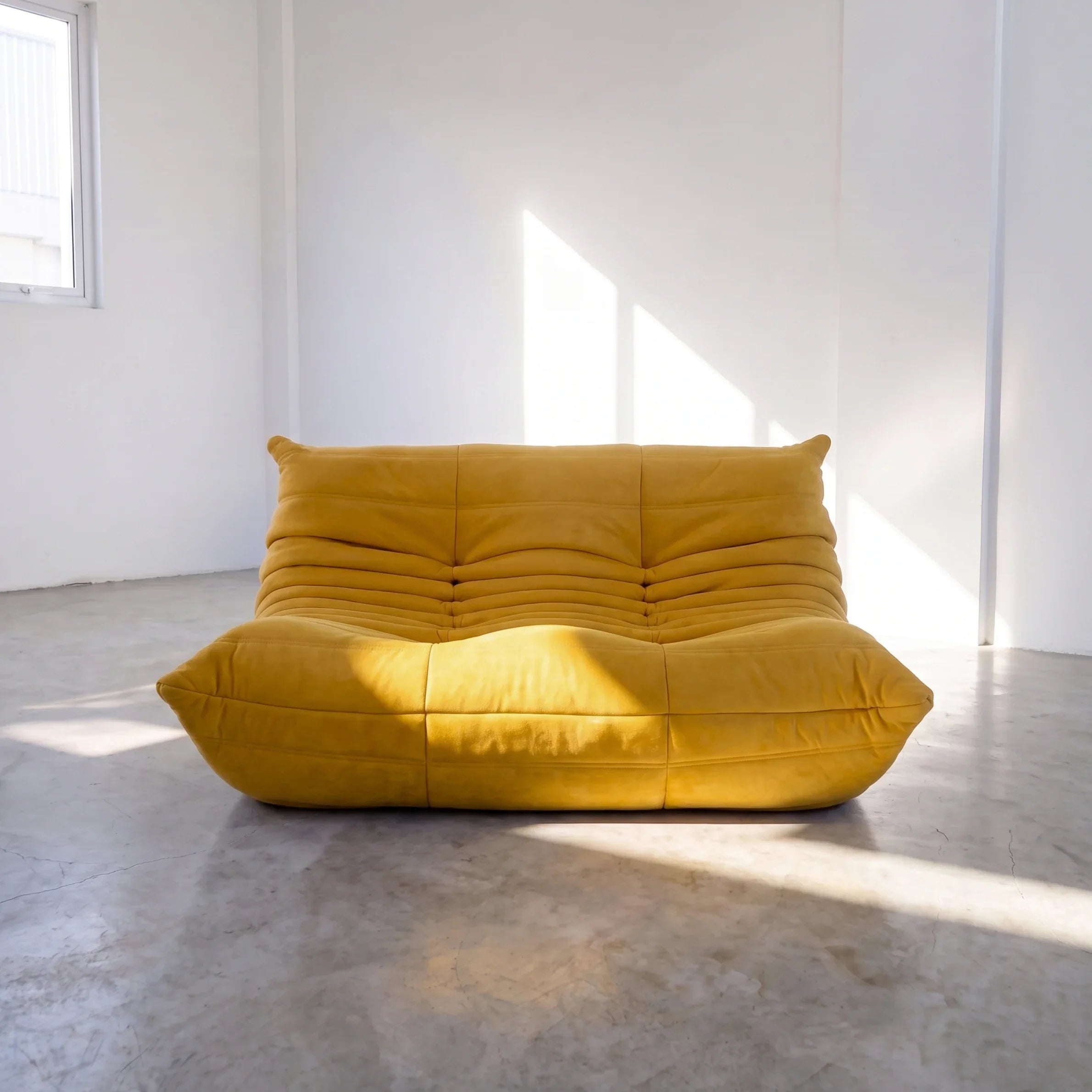 togo sofa dupe in yellow velvet shown from the front in a sunlit studio by vibehaus