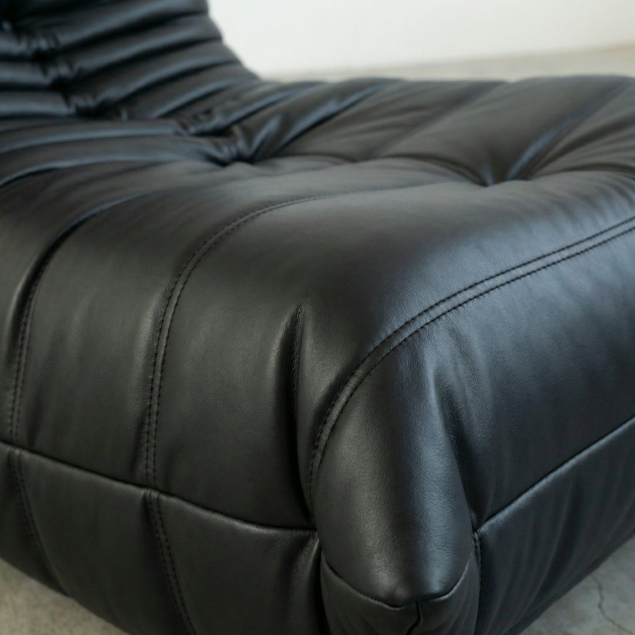 Close up of the Togo Chair dupe in black faux leather by vibehaus