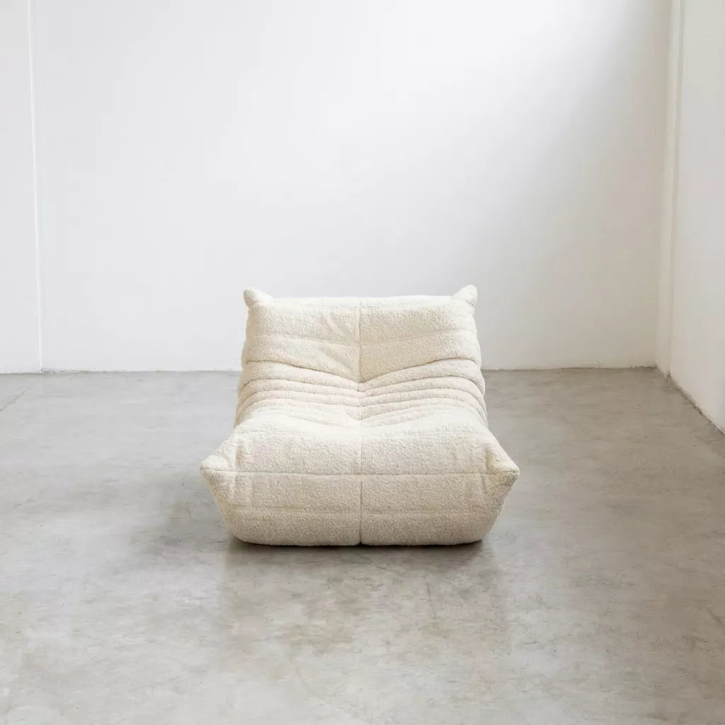Replica of the white boucle Togo-chair by michael ducaroy– low, frameless design with plush channel tufting