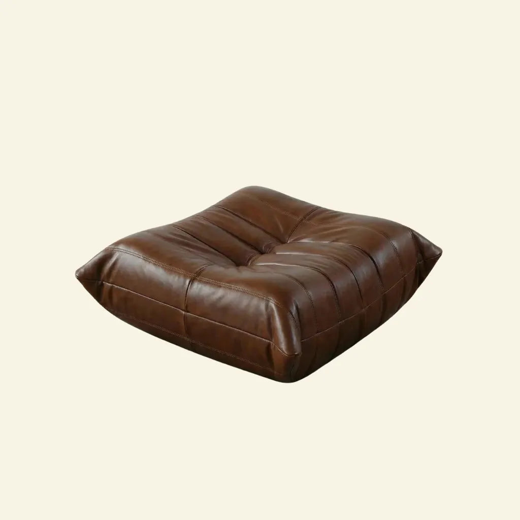 Brown togo leather ottoman dupe on a beige background
