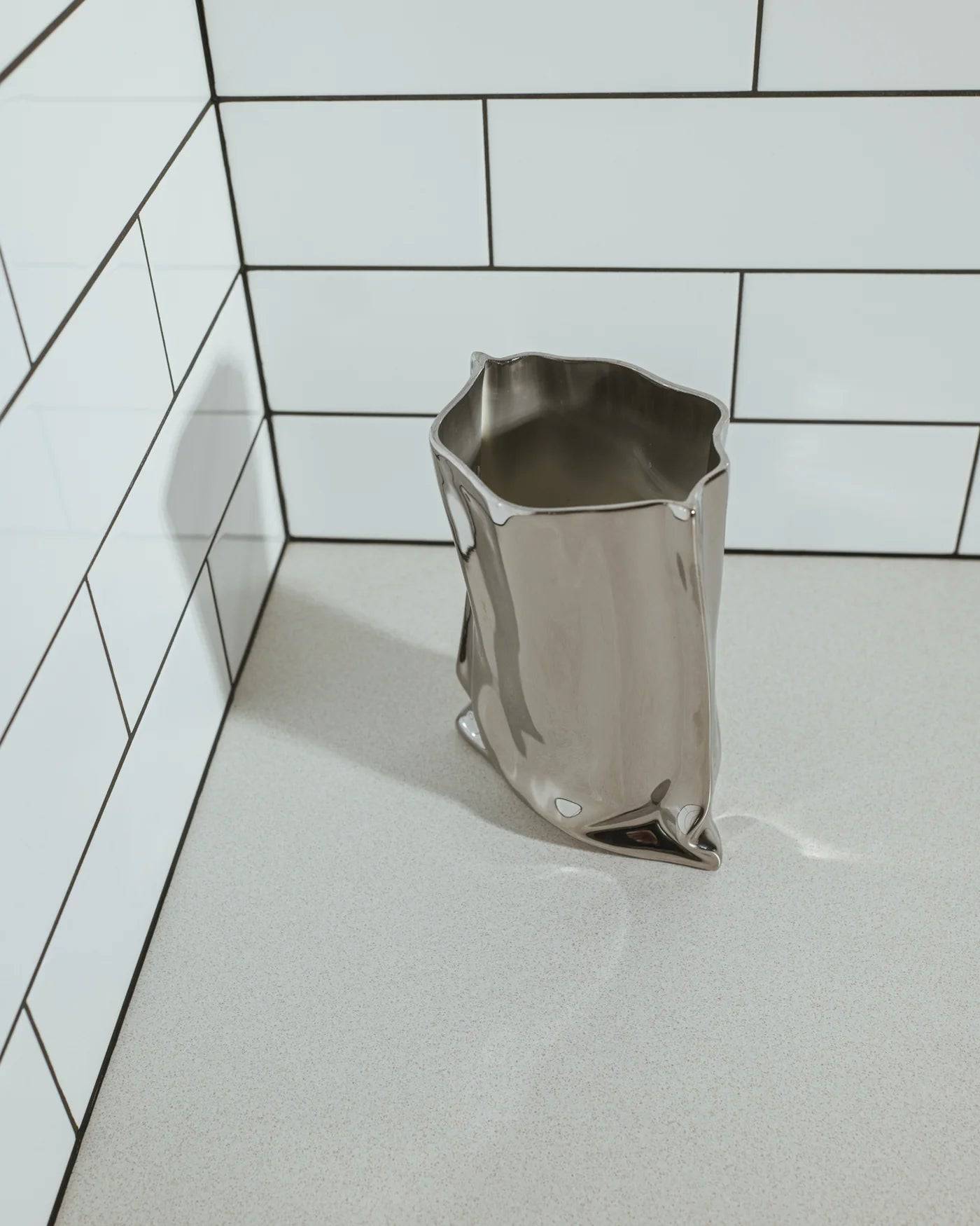 Contemporary chrome ceramic vase with a sculptural ruffled top, ideal for modern interiors and sophisticated floral styling.