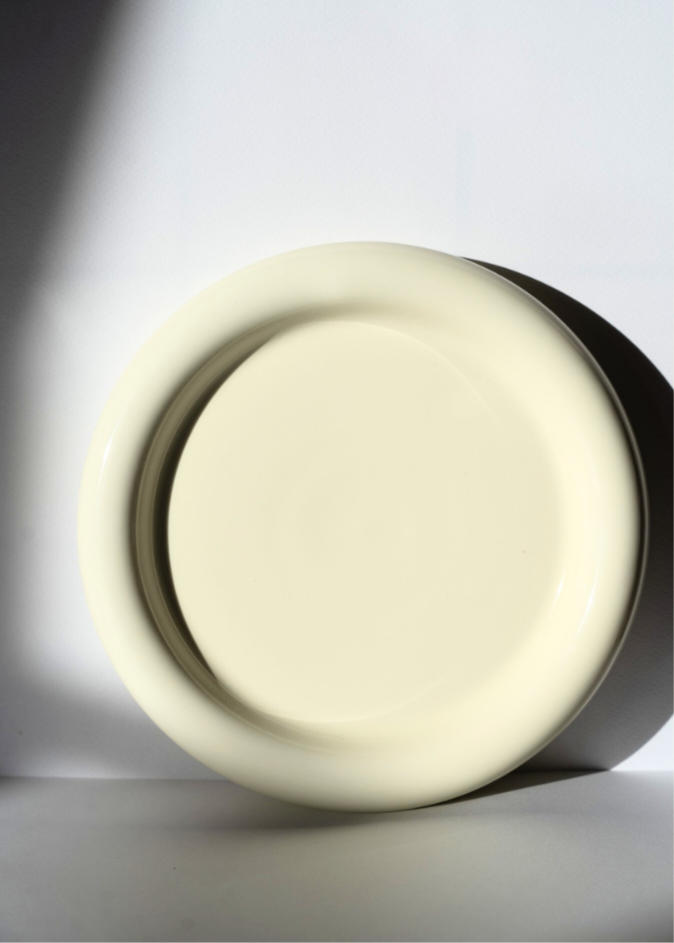 Chunky white ceramic plate inspired by Gustaf Westman in a industrial setting with natural light