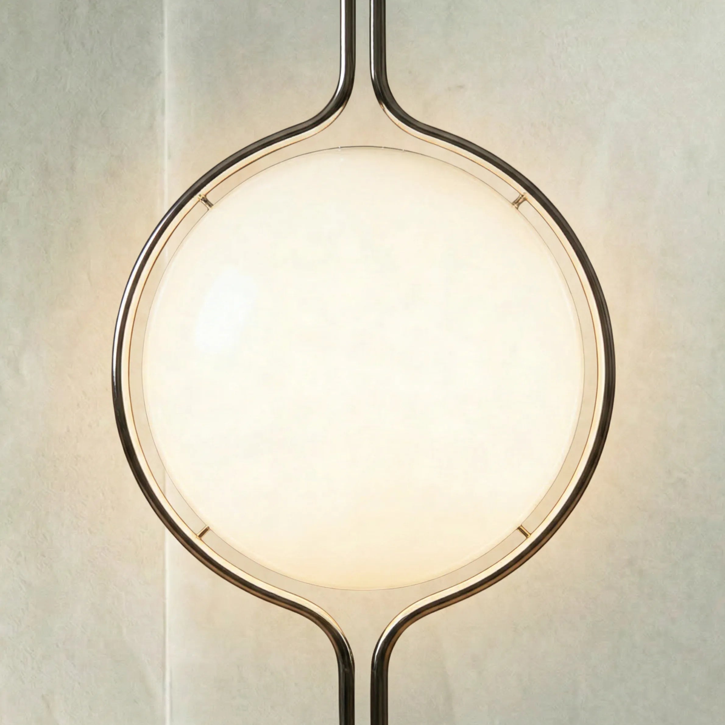 zuru floor to ceiling lamp close-up of upper chrome frame and lit frosted globe on textured wall