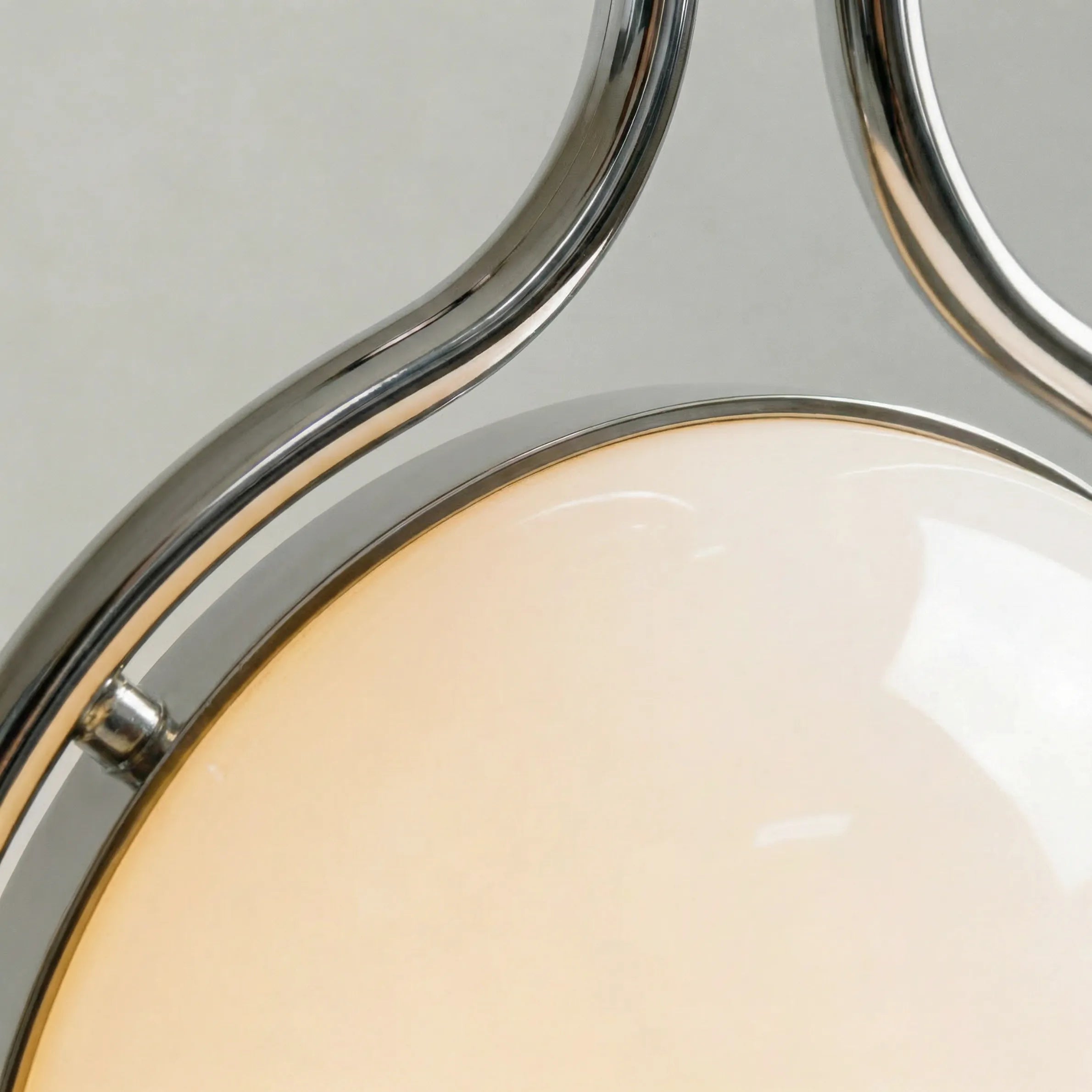zuru floor to ceiling lamp close-up of chrome frame curves around the lit frosted globe