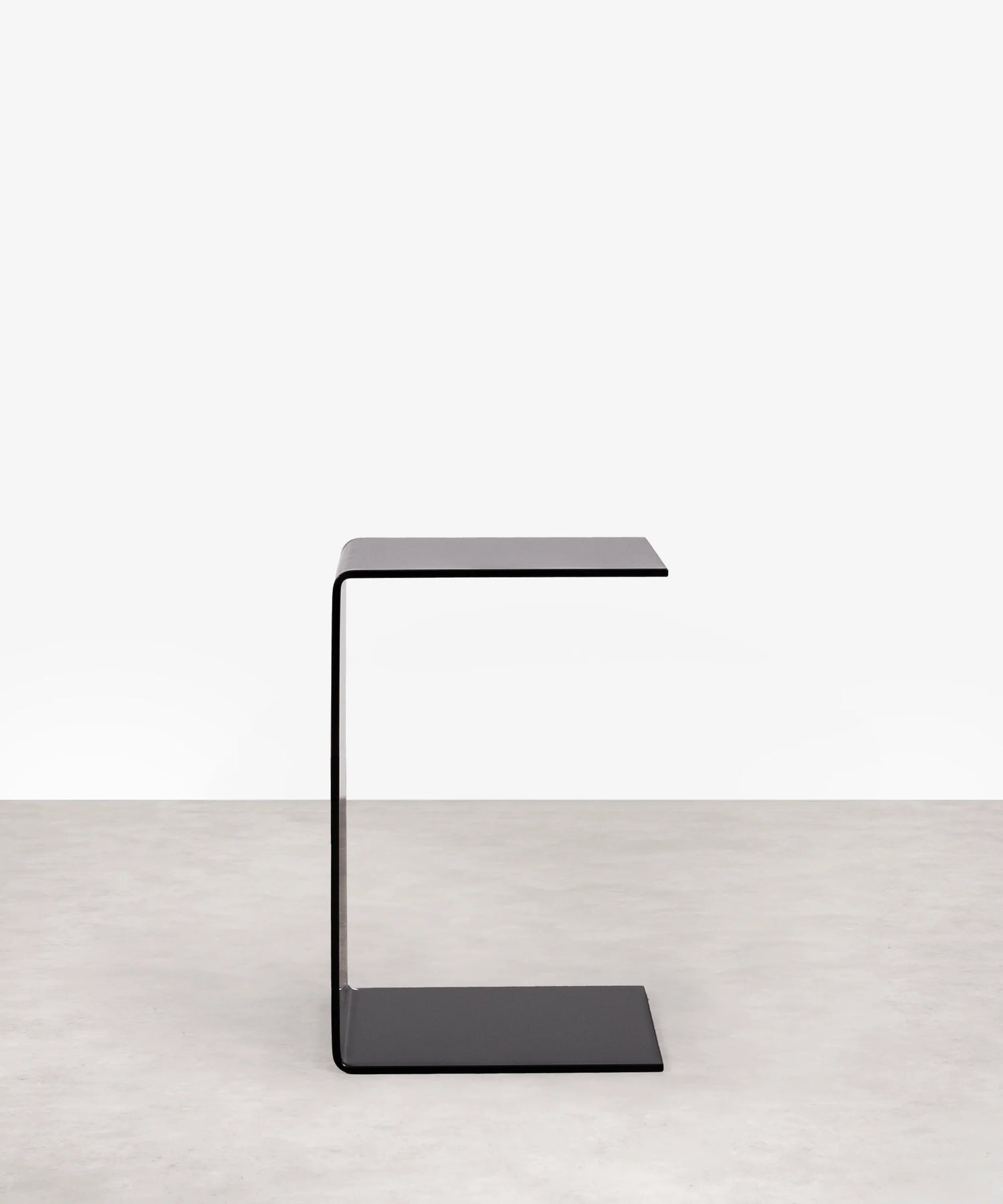 Modern grey c-shaped side table on a white background