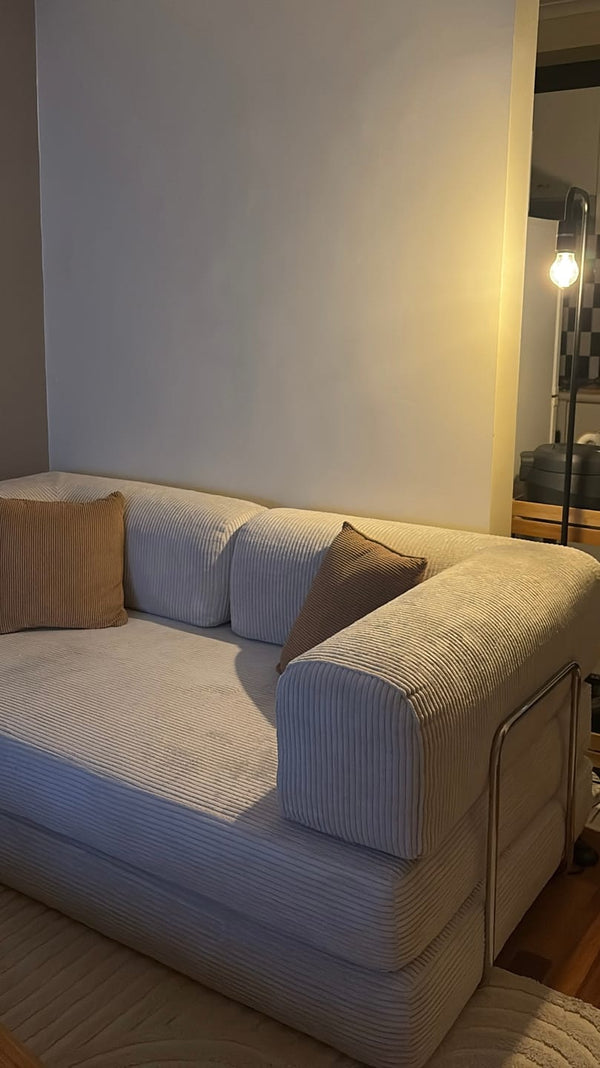 Gray sofa with cushions against a white wall